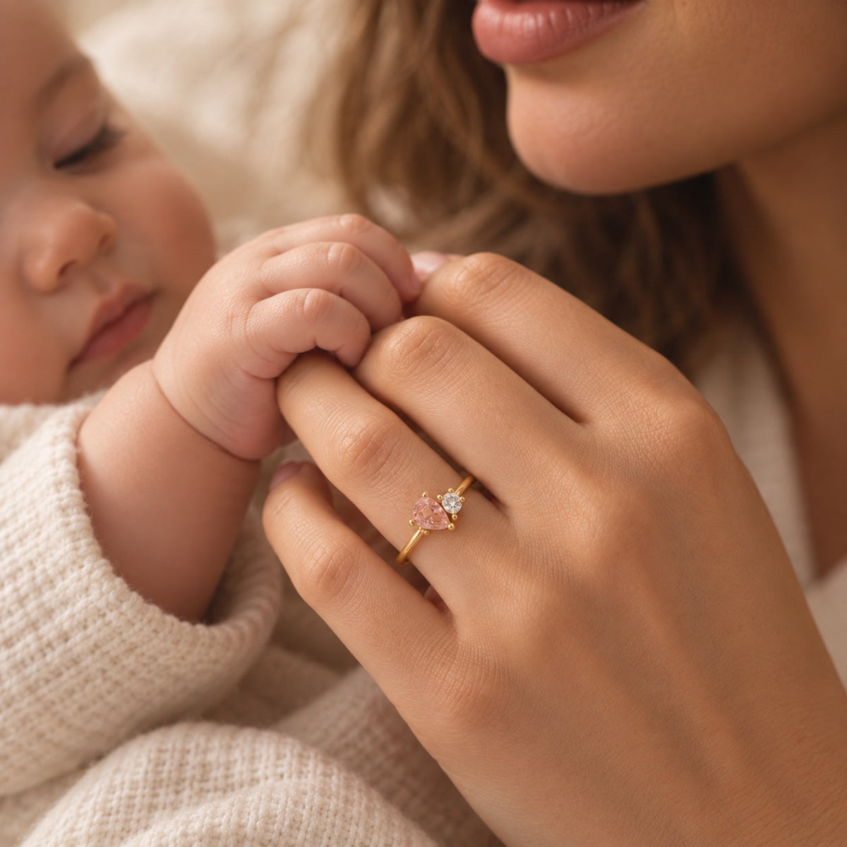 Mother holding her baby's hand wearing a birthstone ring