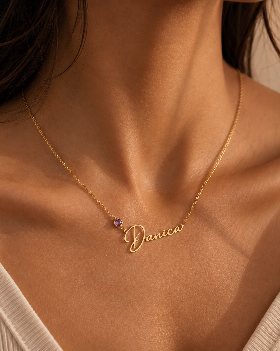 Personalized gold name necklace with purple birthstone worn on model
