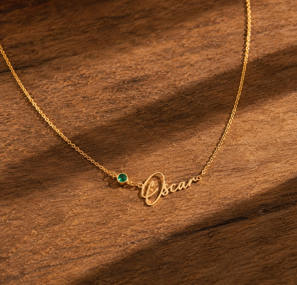 Personalized birthstone name necklace in gold on wood