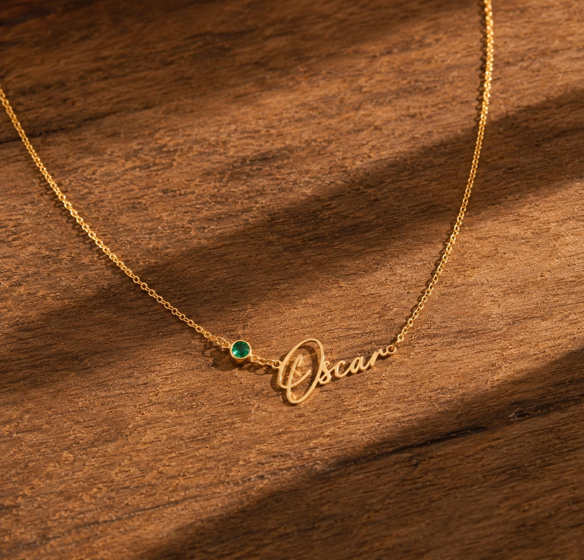 Personalized birthstone name necklace in gold on wood