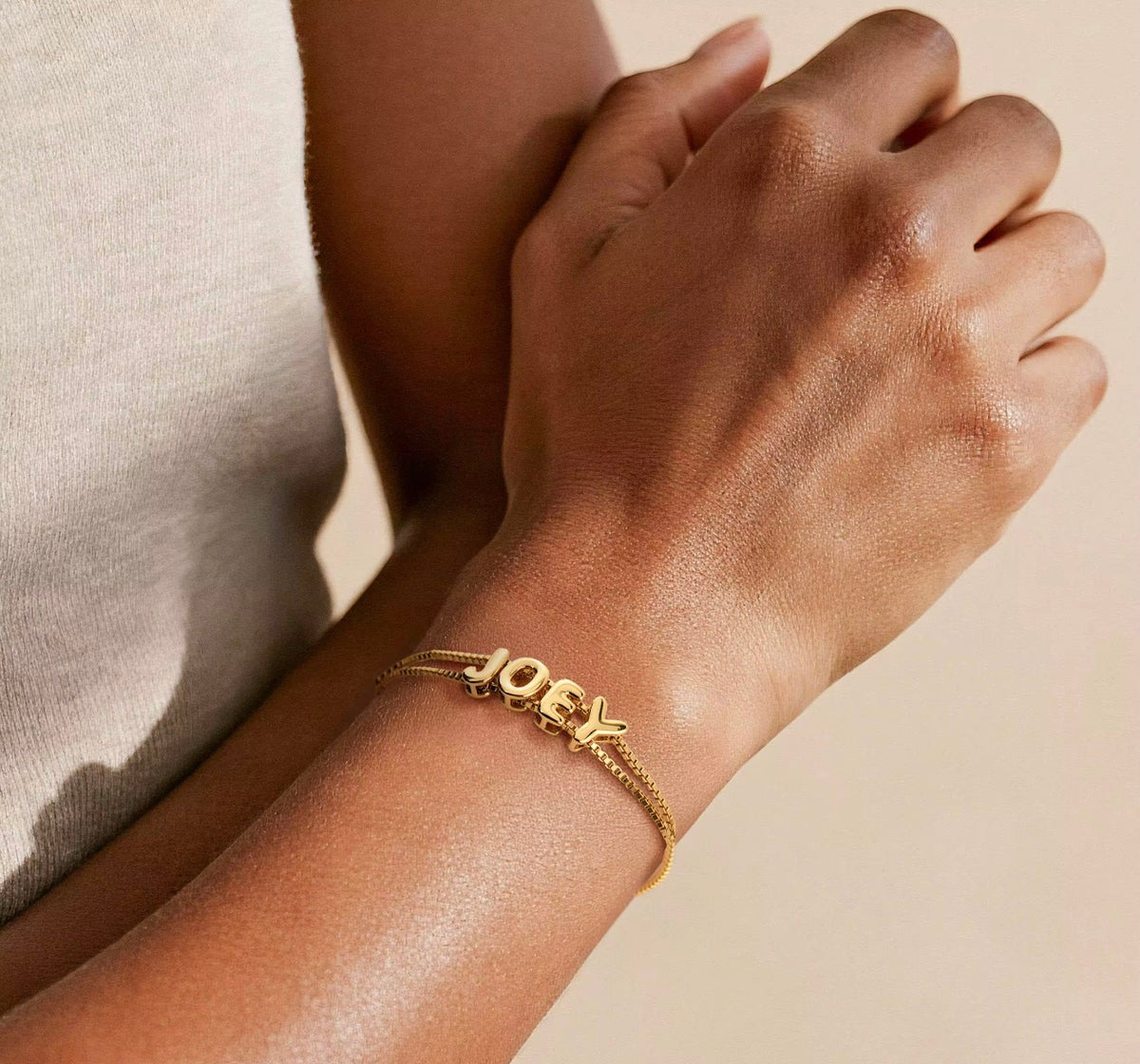 The Bubbly personalized bubble name bracelet in gold on wrist