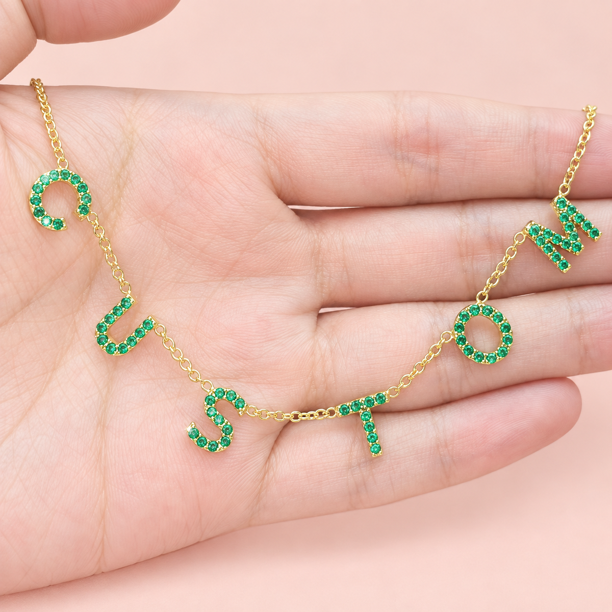 Collier personnalisé à lettres serties vertes sur main