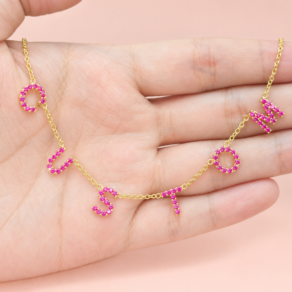 Collier personnalisé à lettres serties roses sur main