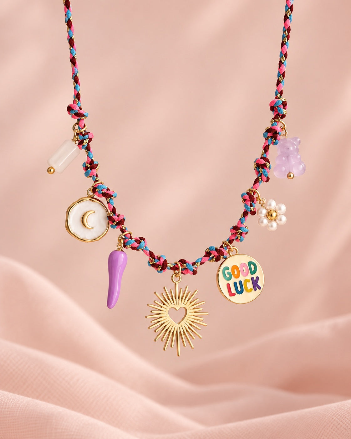 Good Luck charm necklace on soft pink studio background