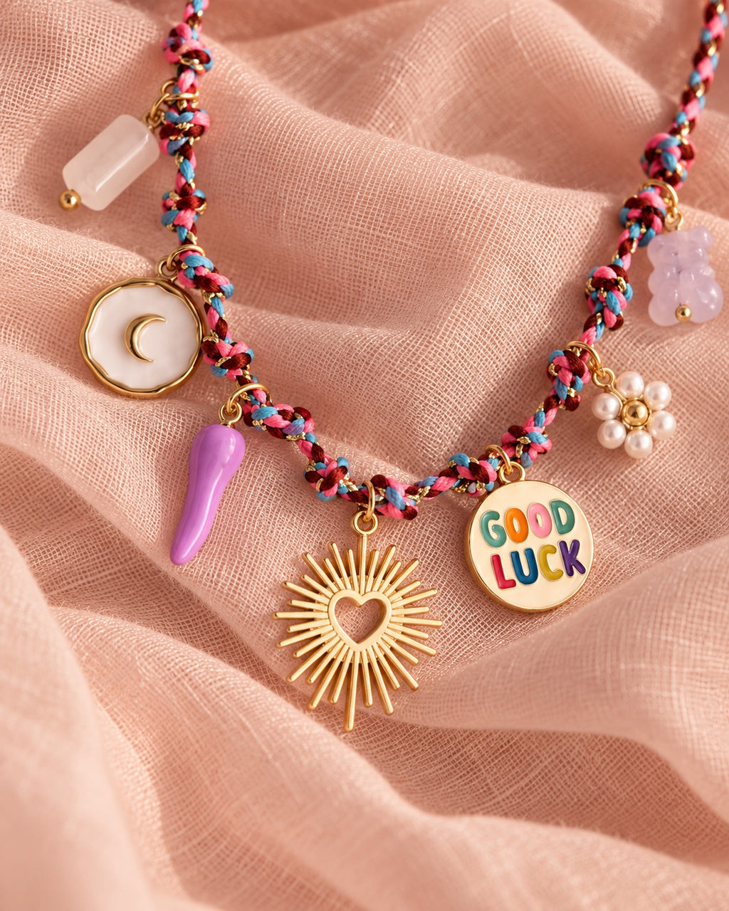 Good Luck charm necklace close-up on blush linen
