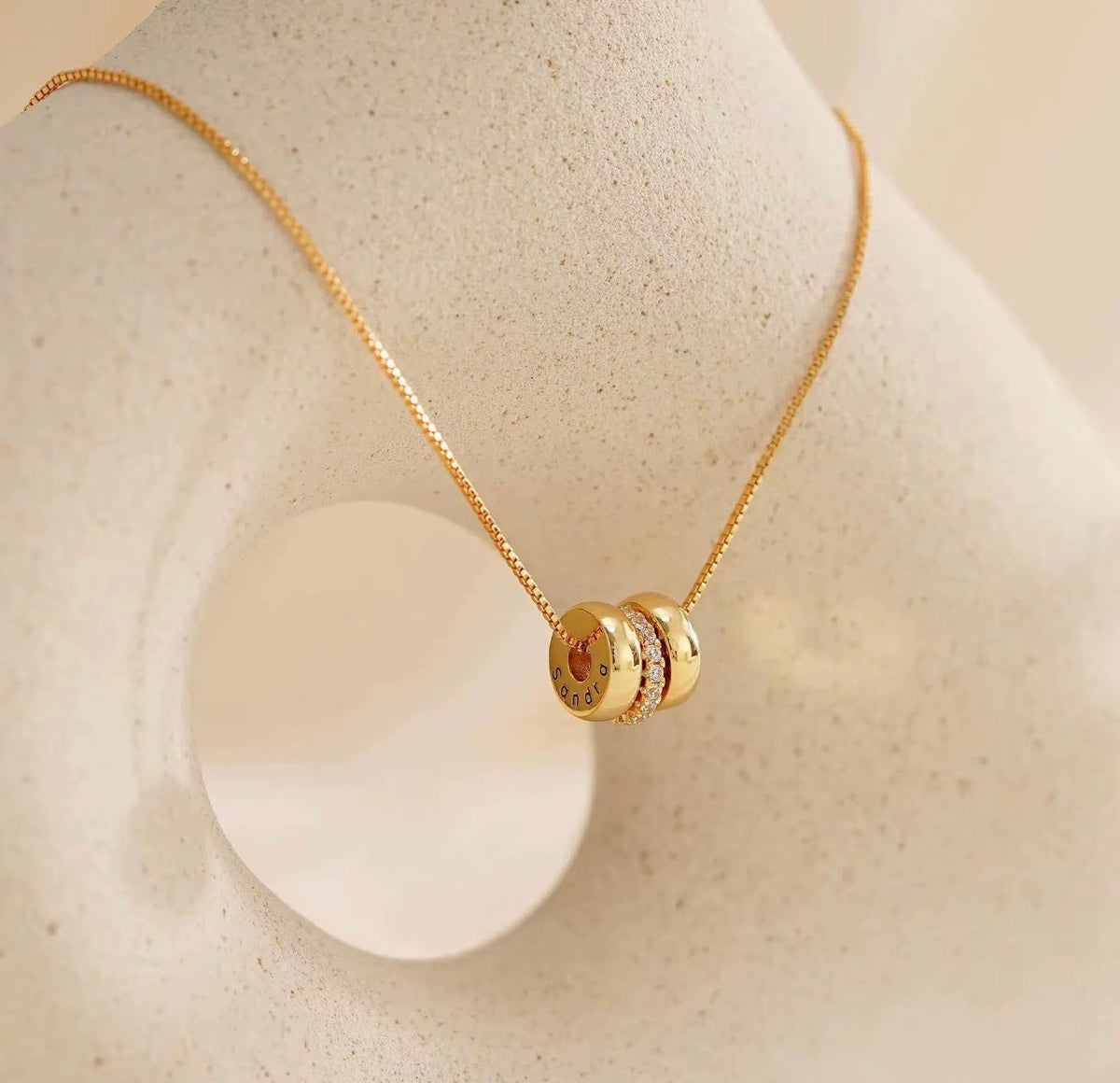 The Lyra gold personalized engraved name bead necklace on jewelry display