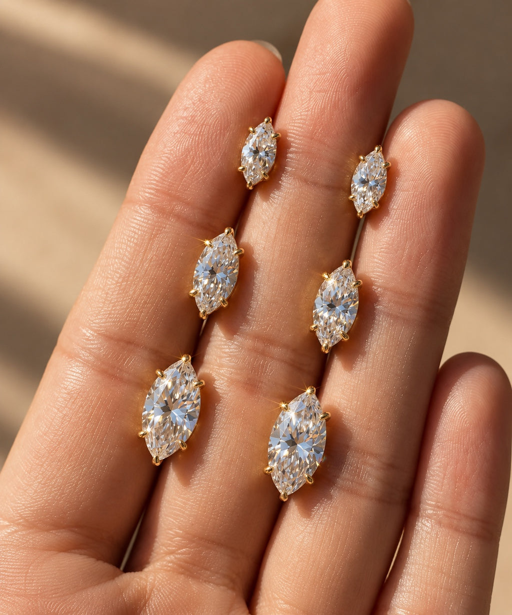 Marquise stud earrings displayed on hand