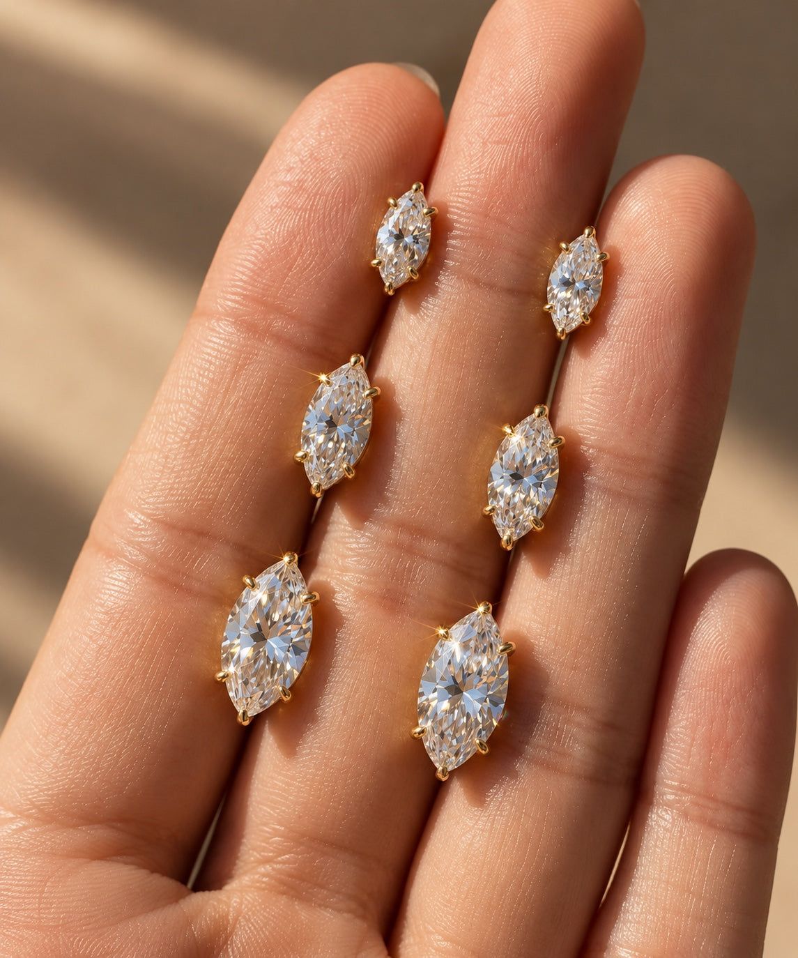 Marquise stud earrings displayed on hand