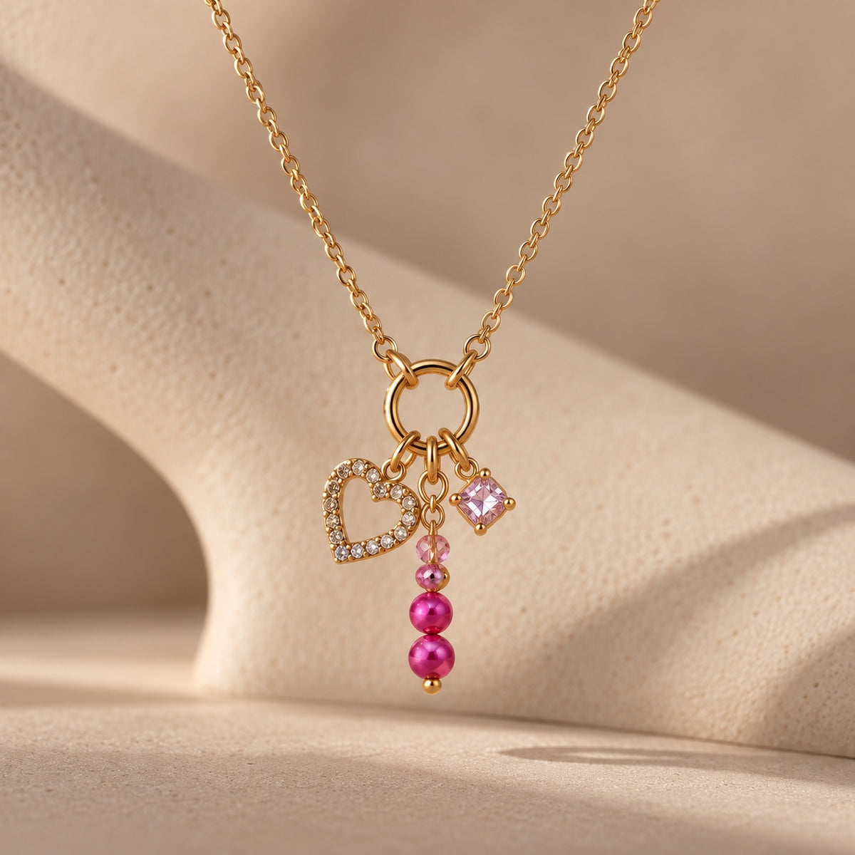 Close-up of The Rosalie pink and gold charm necklace