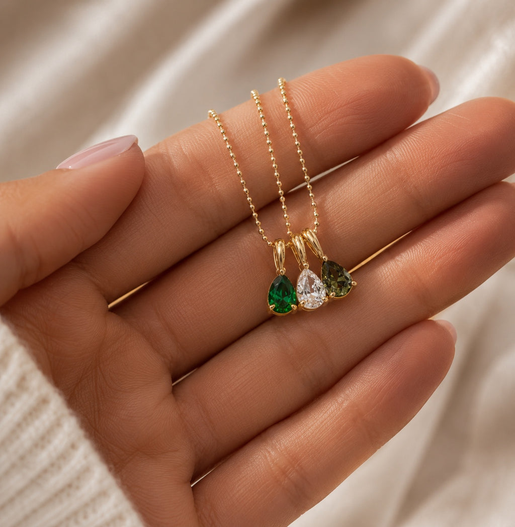 Close-up of The Rosie gold birthstone necklace with three teardrop stones