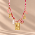 Macro detail of pink and gold necklace charms